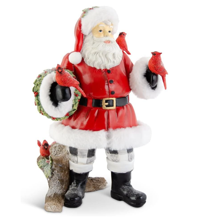 Decorative figurine of a Santa Claus holding a wreath with red cardinals on a white background