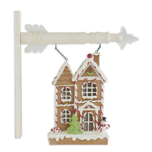 Decorative house ornament with candy cane details on a white background