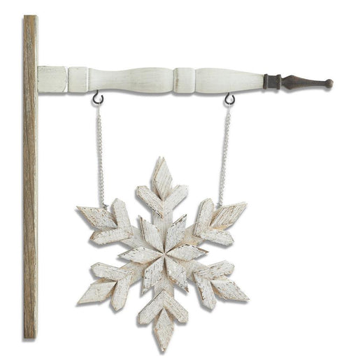 Decorative snowflake hanging from a wooden stand with a white background