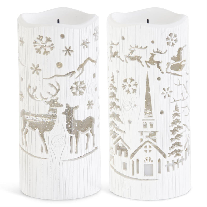Two white LED candles with winter-themed cutouts of reindeer, snowflakes, and a church on a white background.
