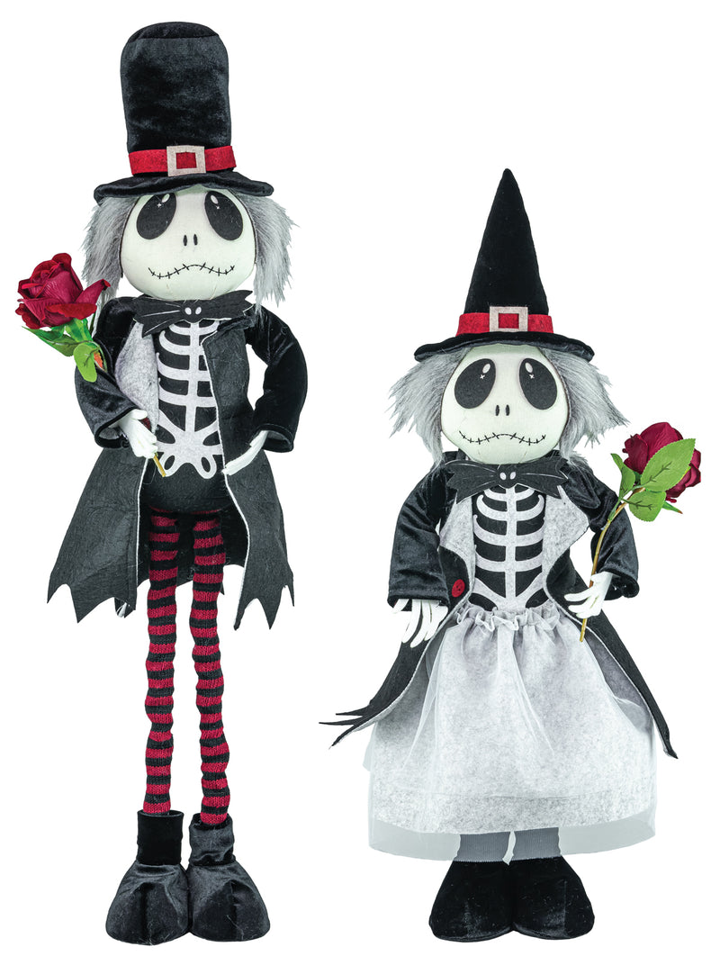 Two Halloween skeleton figurines dressed as Jack Skellington and a witch, standing on a plain white background. The Jack Skellington figure wears a black top hat, black coat, red-and-black striped tights, and holds a red rose.