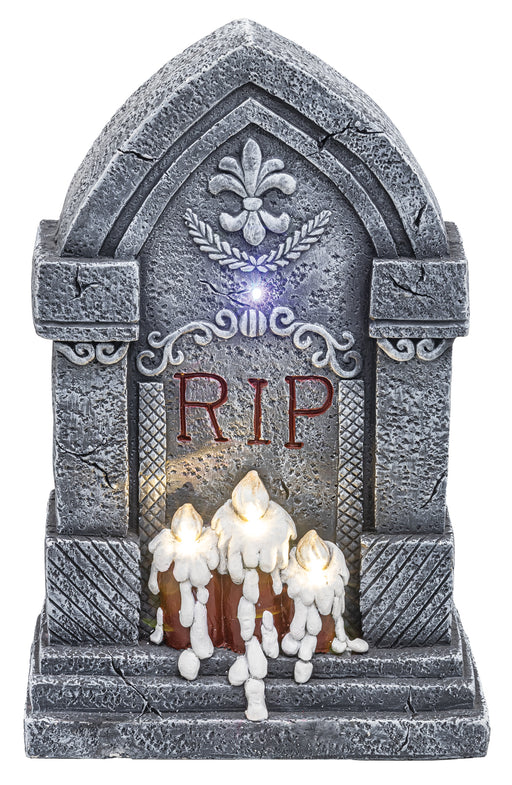 A gothic-style Halloween tombstone decoration with a faux-stone gray surface, illuminated LED lights, and three white wax-dripping candles at the base. The front features the letters 'RIP' in red.