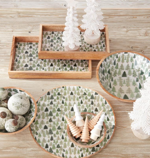 Wooden trays and bowls with forest pattern on a wooden surface