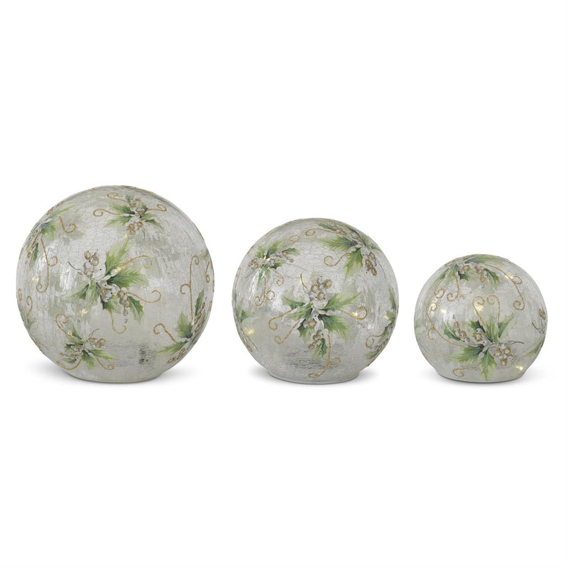 Three decorative glass spheres with floral patterns on a white background