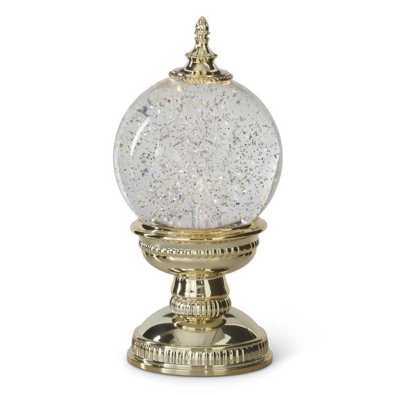 Decorative crystal ball with gold base and lid on a white background