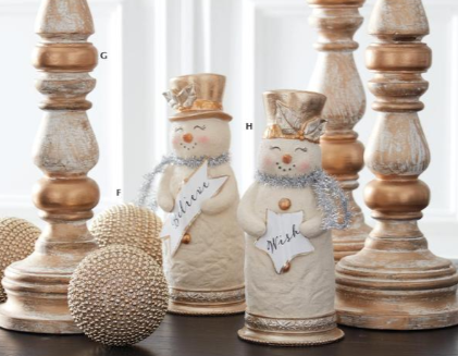 Decorative snowmen with wooden candlesticks and textured spheres on a neutral background