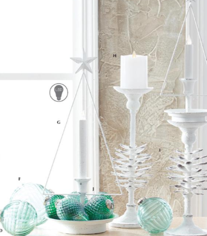 Decorative items including white candlesticks, green glass ornaments, and a star-shaped object against a textured wall.