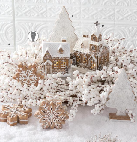 Decorative scene with gingerbread cookies shaped like snowflakes and a small village model on a textured white background.