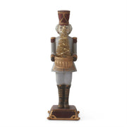 A decorative nutcracker figurine with a gold LED tree on its chest, wearing a traditional soldiery uniform with a red hat.