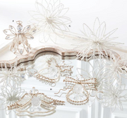 Decorative items including a angel figurine, air plants, and jewelry on a white surface.