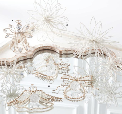 Decorative items including a angel figurine, air plants, and jewelry on a white surface.