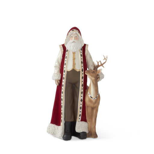 Decorative figure of Santa Claus standing next to a deer on a white background