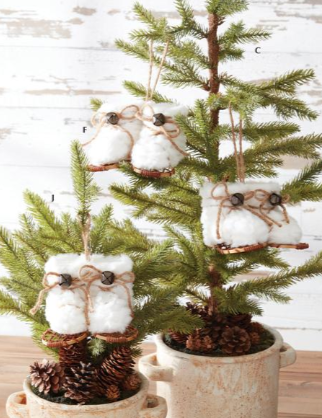 Small potted Christmas trees with decorative elements on a wooden surface