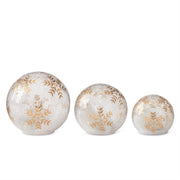 Three decorative spherical ornaments with gold leaf patterns on a white background