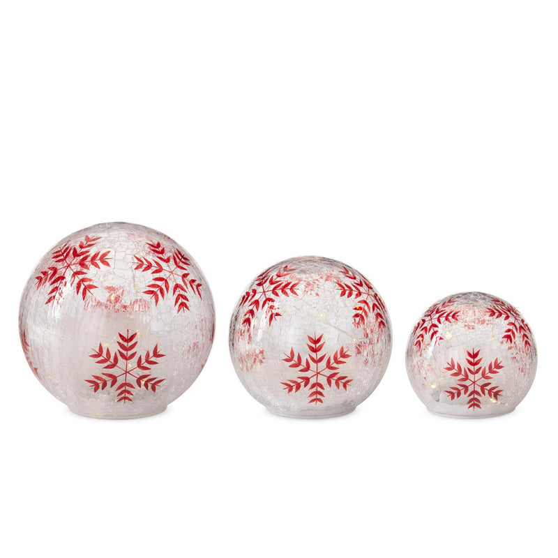 Three decorative balls with red snowflake patterns on a white background