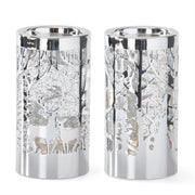 Two silver candle holders with deer and tree cutouts on a white background