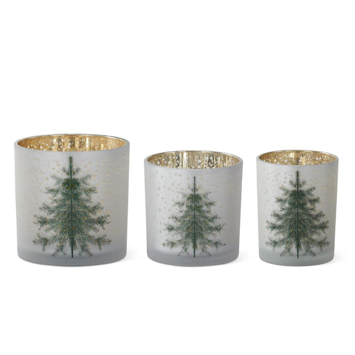 Three decorative candle holders with tree designs on a white background