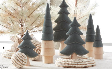 Decorative Christmas trees made of wood and felt on a white surface with a blurred background.