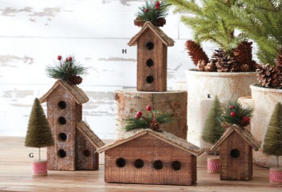 Set of decorative wooden birdhouses with Christmas decorations on a wooden surface.