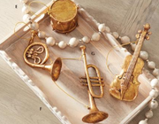 Decorative items including a violin, trumpet, and other musical-themed ornaments on a textured surface.