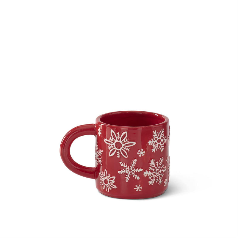 Red mug with white snowflake patterns on a white background