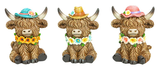 Three decorative Highland cow figurines with long brown shaggy fur, wearing colorful floral hats and flower garlands, shown side by side on a white background.