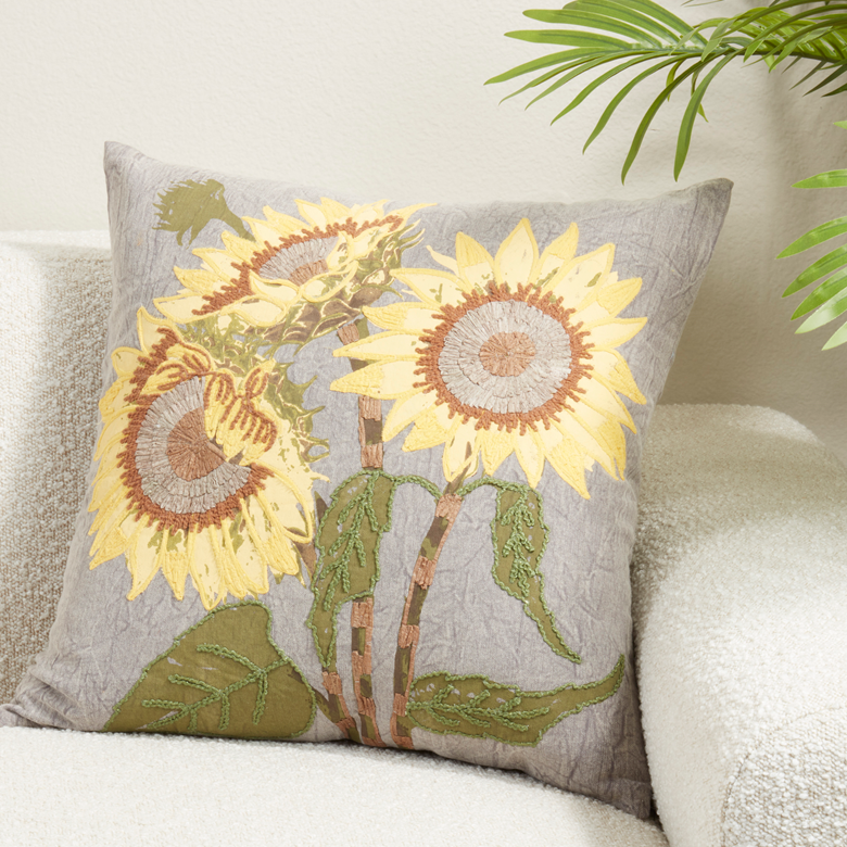 Decorative pillow with sunflower design on a white couch