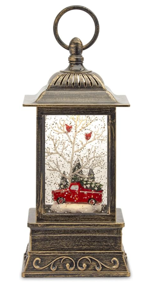 Decorative lantern with a Christmas scene featuring a red truck and trees.
