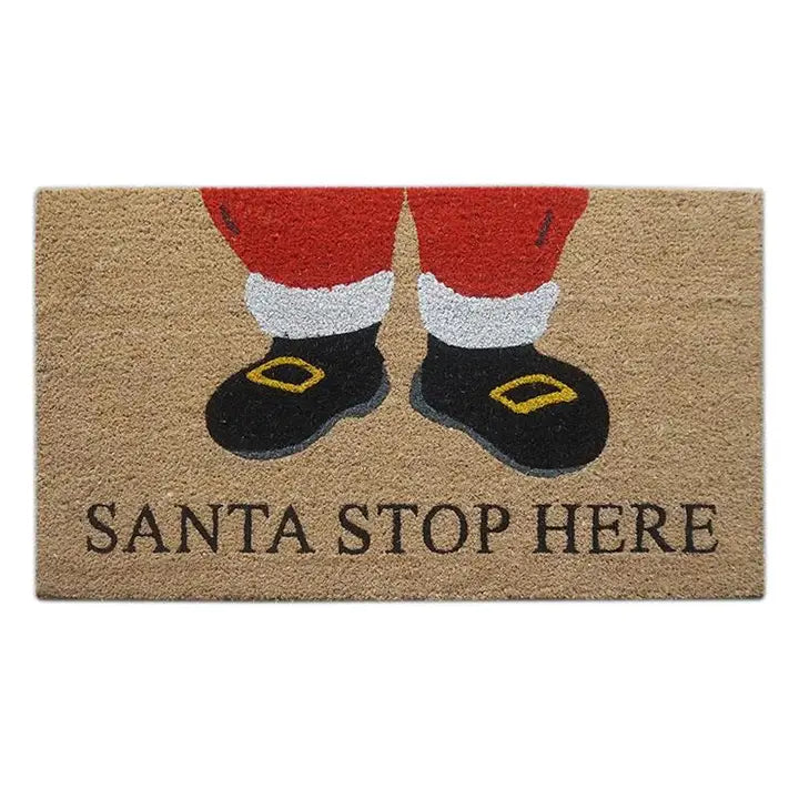 A rectangular coir doormat with a printed illustration of Santa's legs in red pants with white cuffs and black boots with gold buckles, above the words 'SANTA STOP HERE' in dark lettering.