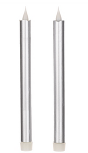 Two silver candles with white wicks on a white background