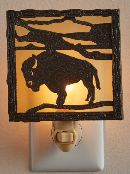 Night light with a bison silhouette design on a beige wall.