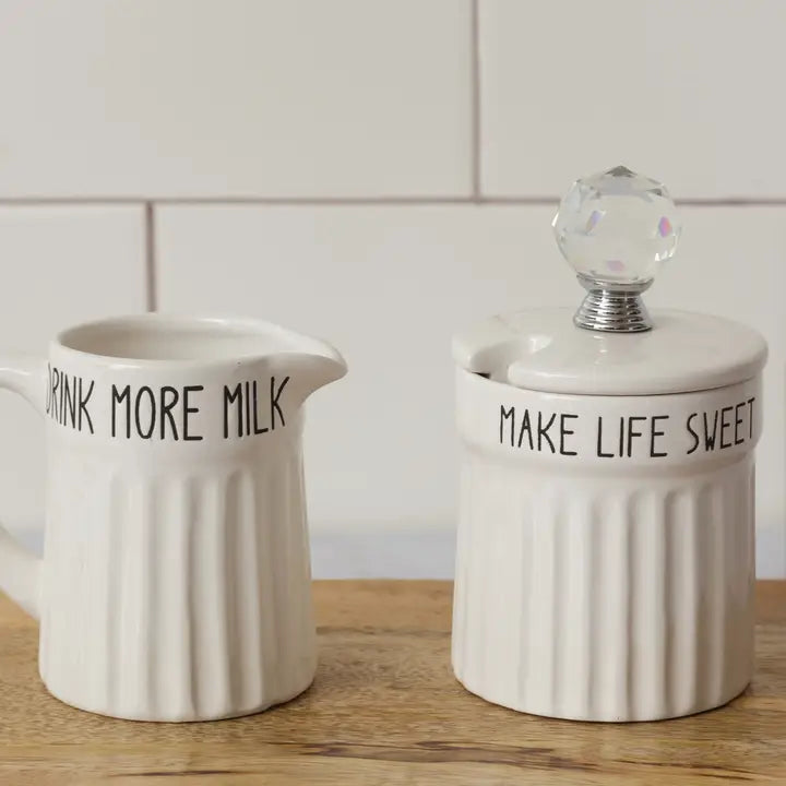 Two ceramic containers with text on a wooden surface and tiled wall background
