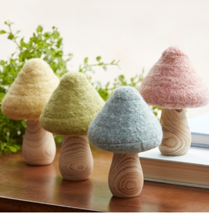 Set of colorful mushroom-shaped objects on a wooden surface with a natural background