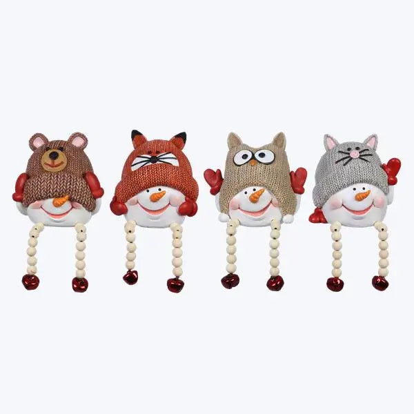 Four animal-themed baby rattles with knit hats on a white background
