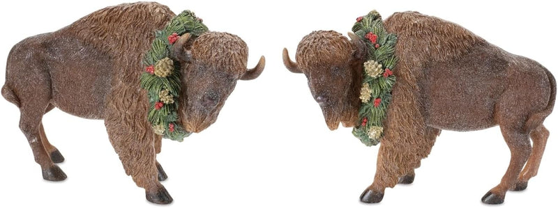 Two bison figurines wearing Christmas wreaths on a white background