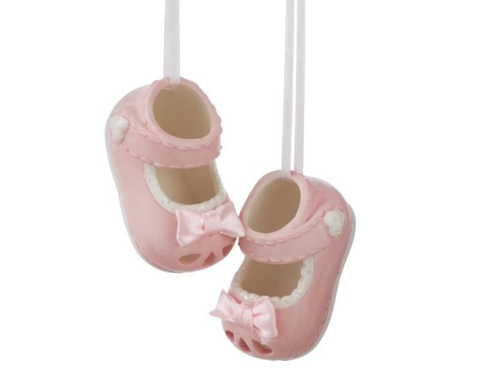 A pair of blue ceramic baby bootie ornaments hanging by strings, against a white background.
