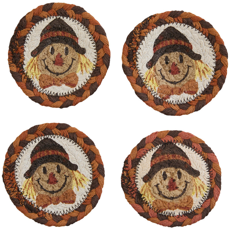 Four round woven coasters with scarecrow designs on a white background