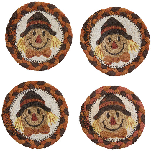Four round woven coasters with scarecrow designs on a white background