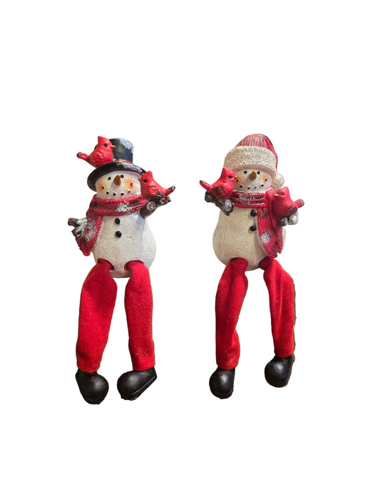 Two snowman figurines with red scarves and hats on a white background