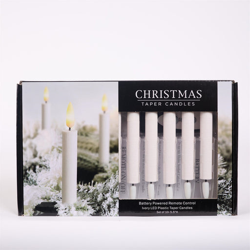 Packaged Christmas taper candles with remote control on a white background