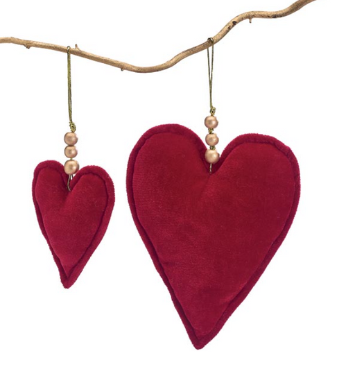 Red heart-shaped decorations hanging from a branch on a white background
