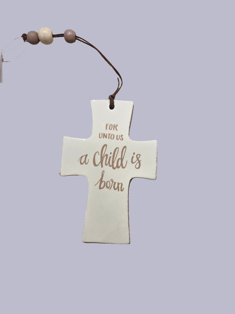 Decorative cross ornament with 'For unto us a child is born' text on a light purple background