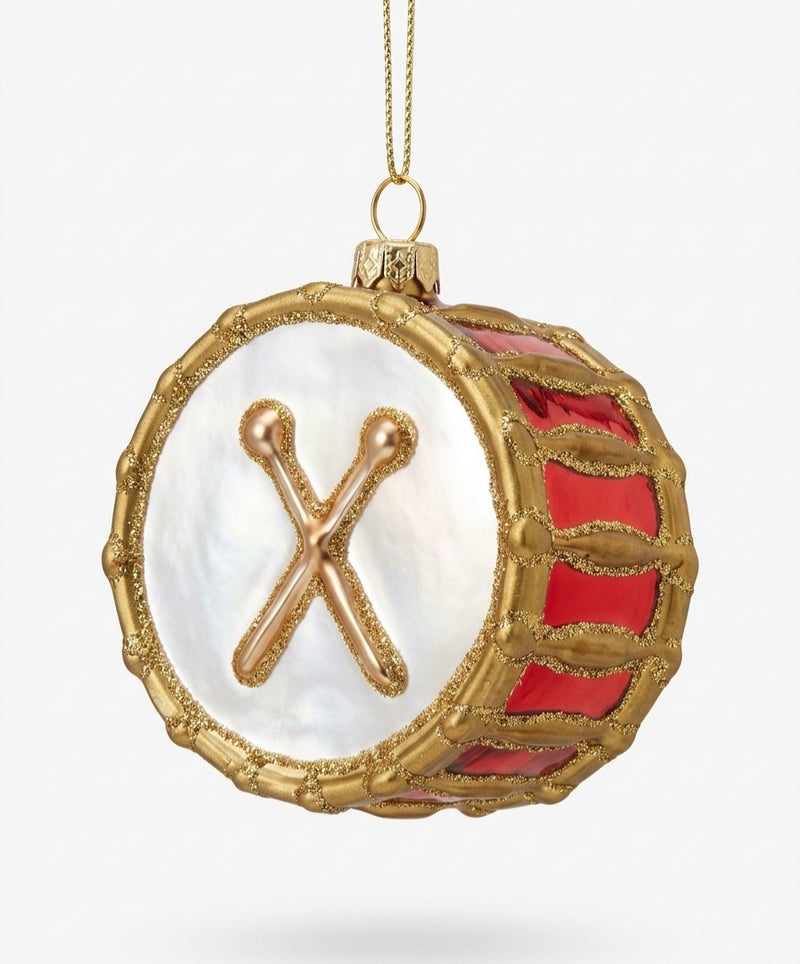 A decorative drum-shaped hanging ornament with a white mother-of-pearl face, gold trim, red side panels, and a gold hanging loop on a light gray background.