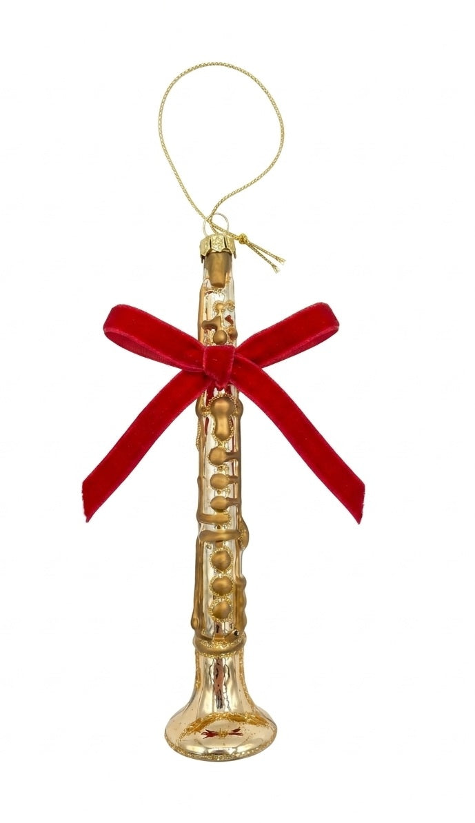 A gold angel-shaped holiday ornament shaped like a flute, featuring a red velvet bow and a gold hanging string, set against a plain white background.