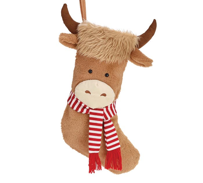 A plush Highland cow Christmas stocking ornament in light brown with a fluffy cream mane, small brown horns, and a red and white striped scarf, shown against a plain white background.