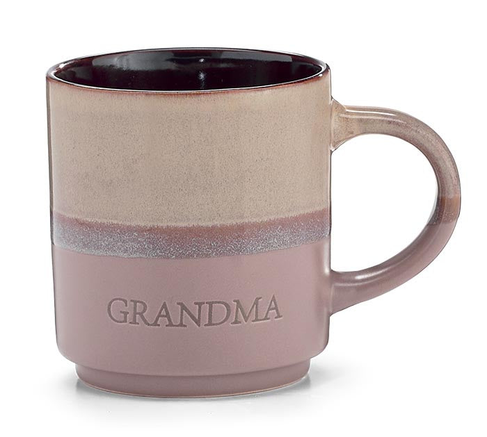 A ceramic mug with a two-tone design, featuring a textured beige top half and a dusty mauve-pink bottom half with the word 'GRANDMA' embossed on the front. The handle and interior are in a matching dusty mauve color.