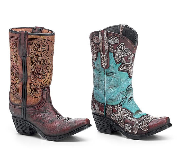A pair of western cowboy boots shown from the front and side on a white background. One boot is brown with carved floral detailing, and the other is turquoise blue with brown and silver western embroidery.