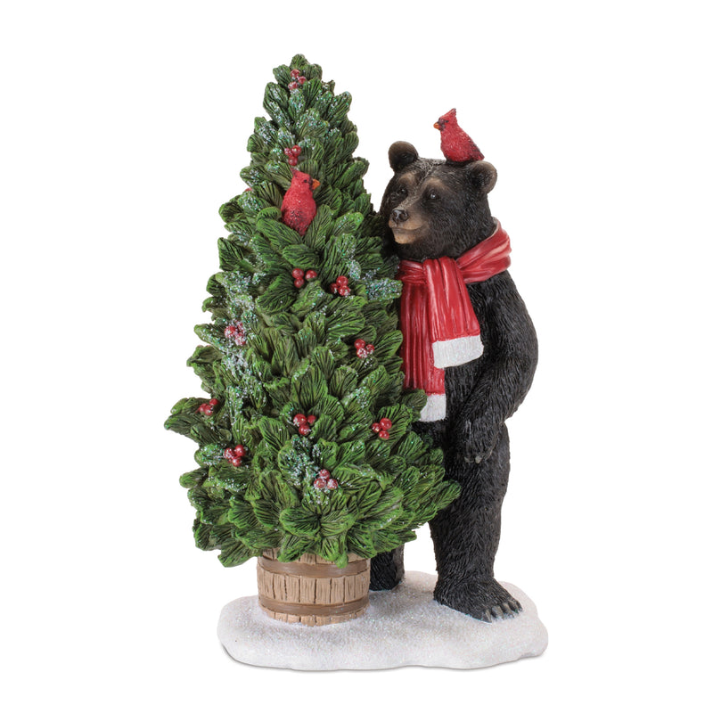 Bear figurine with a Christmas tree and cardinal bird on a white background