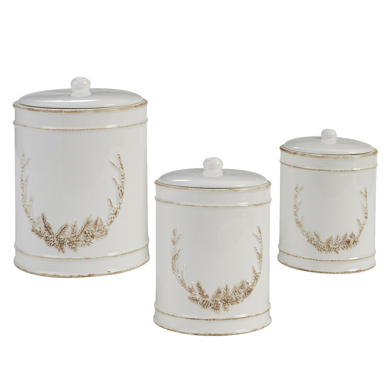 Set of three white canisters with gold wreath designs on a white background