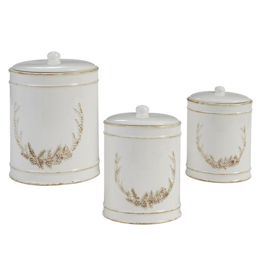 Set of three white canisters with gold wreath designs on a white background